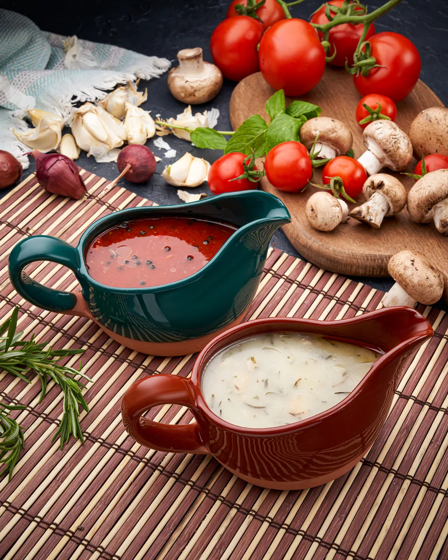 Seramik sos kapları, domates ve mantarlarla yemek fotoğrafı